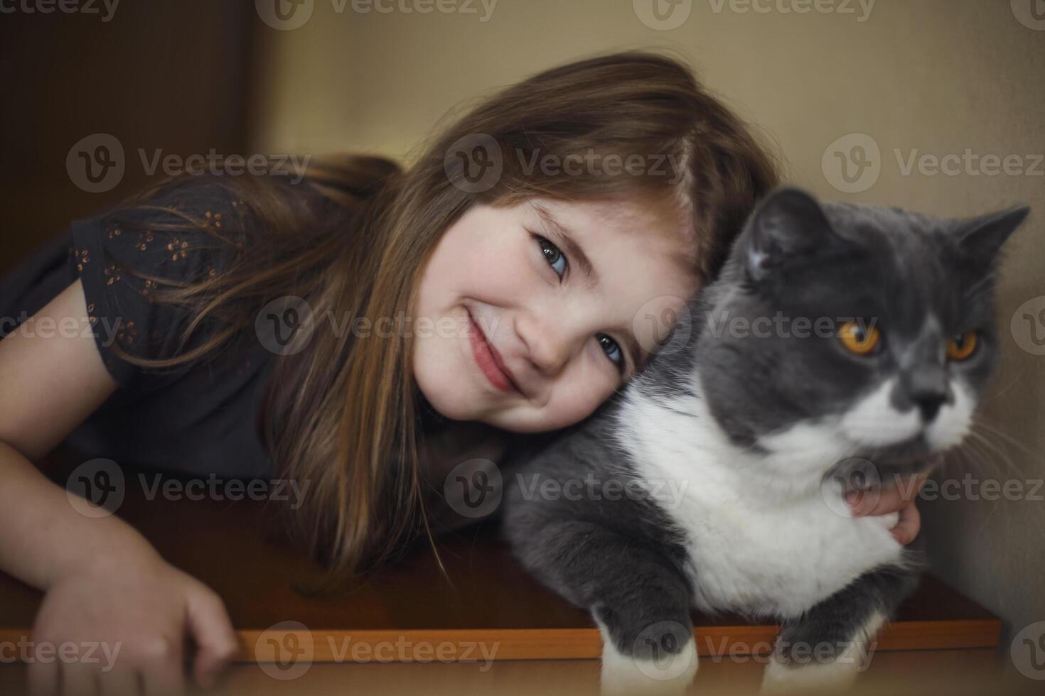 Cute little girl with cat hugging at home. First pet photo