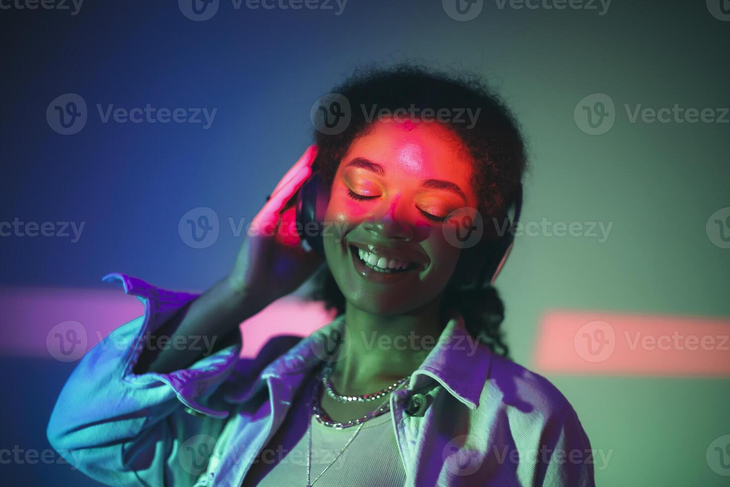 Young happy african american woman in headphones listening to music, enjoying high quality sound photo