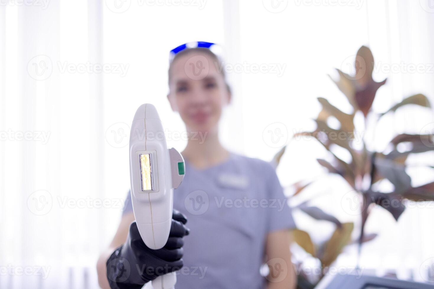 A close-up of a part of the laser hair removal machine. A dermatologist holds a device for hair removal and skin rejuvenation. Aesthetic cosmetology and photo epilation.