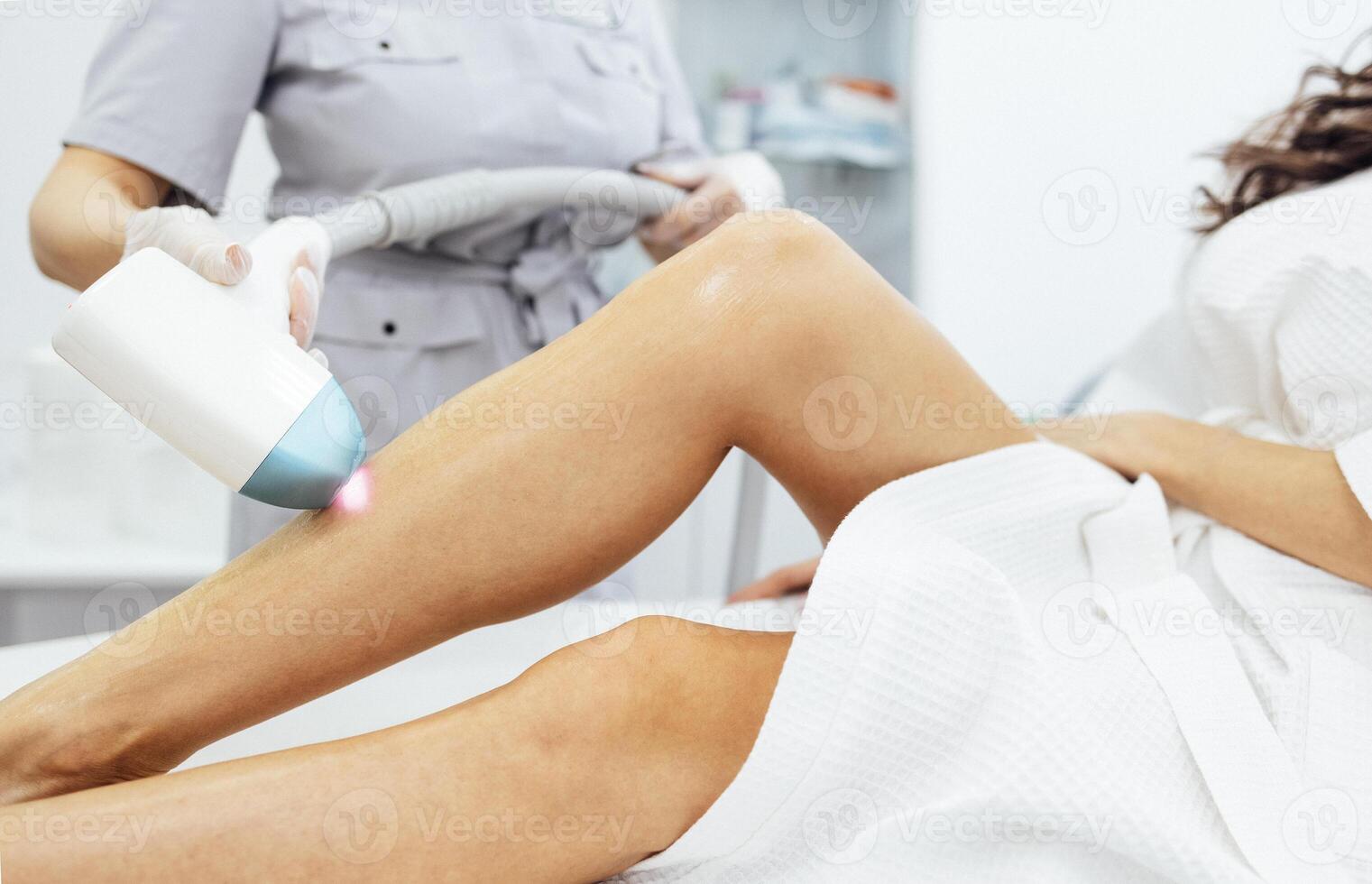 Woman client receiving laser hair removal procedure on body in beauty clinic. photo