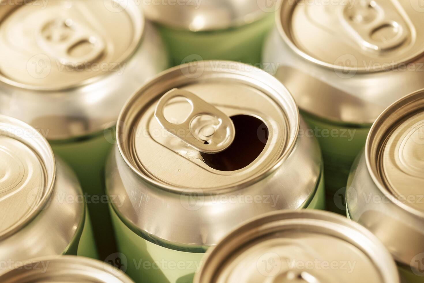 A collection of aluminum cans. One open bottle in the middle. Pattern of metal cans. photo