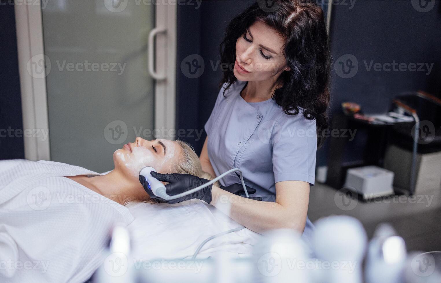 Closeup of face of beautiful relaxing girl undergoing hardware cosmetology procedure in spa photo