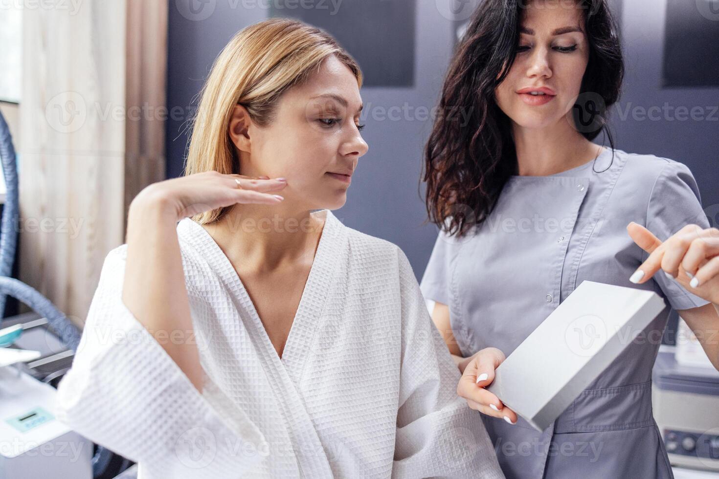 Pretty caucasian beautician communicates with her female client. photo
