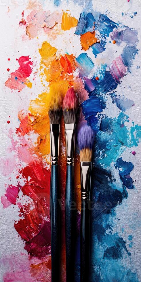 Colorful paintbrushes on a vibrant palette with paint. photo
