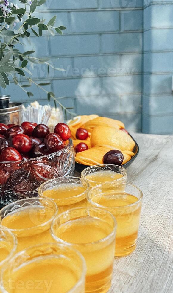 a table with a bowl of fruit and a bowl of juice photo