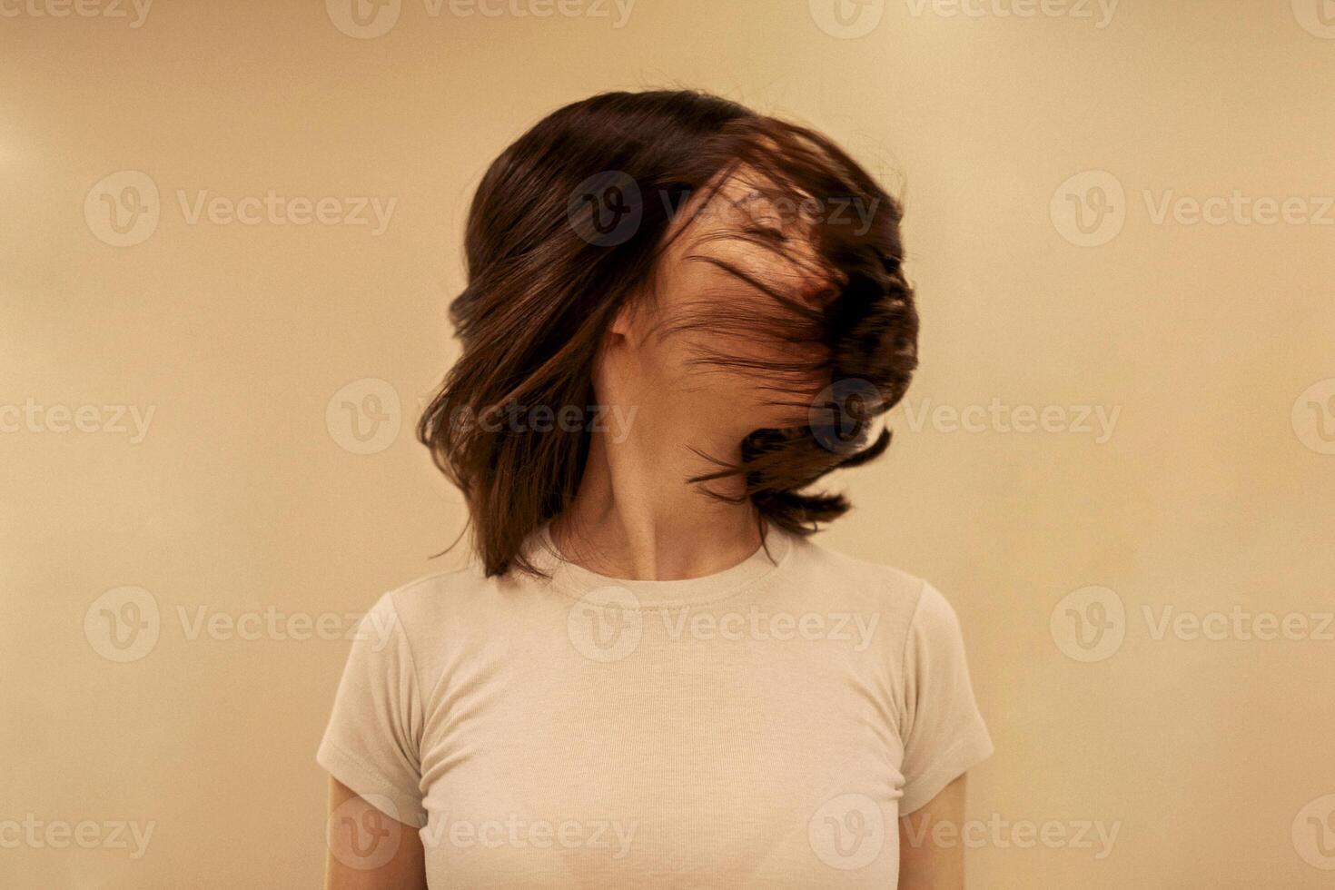 Close up of female portrait of attractive girl turns her head to the side and her hair fly photo