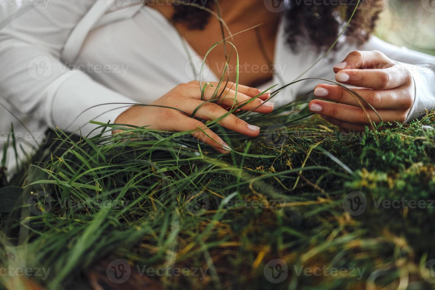 Close up of hands of the woman touching the grass, feeling nature photo