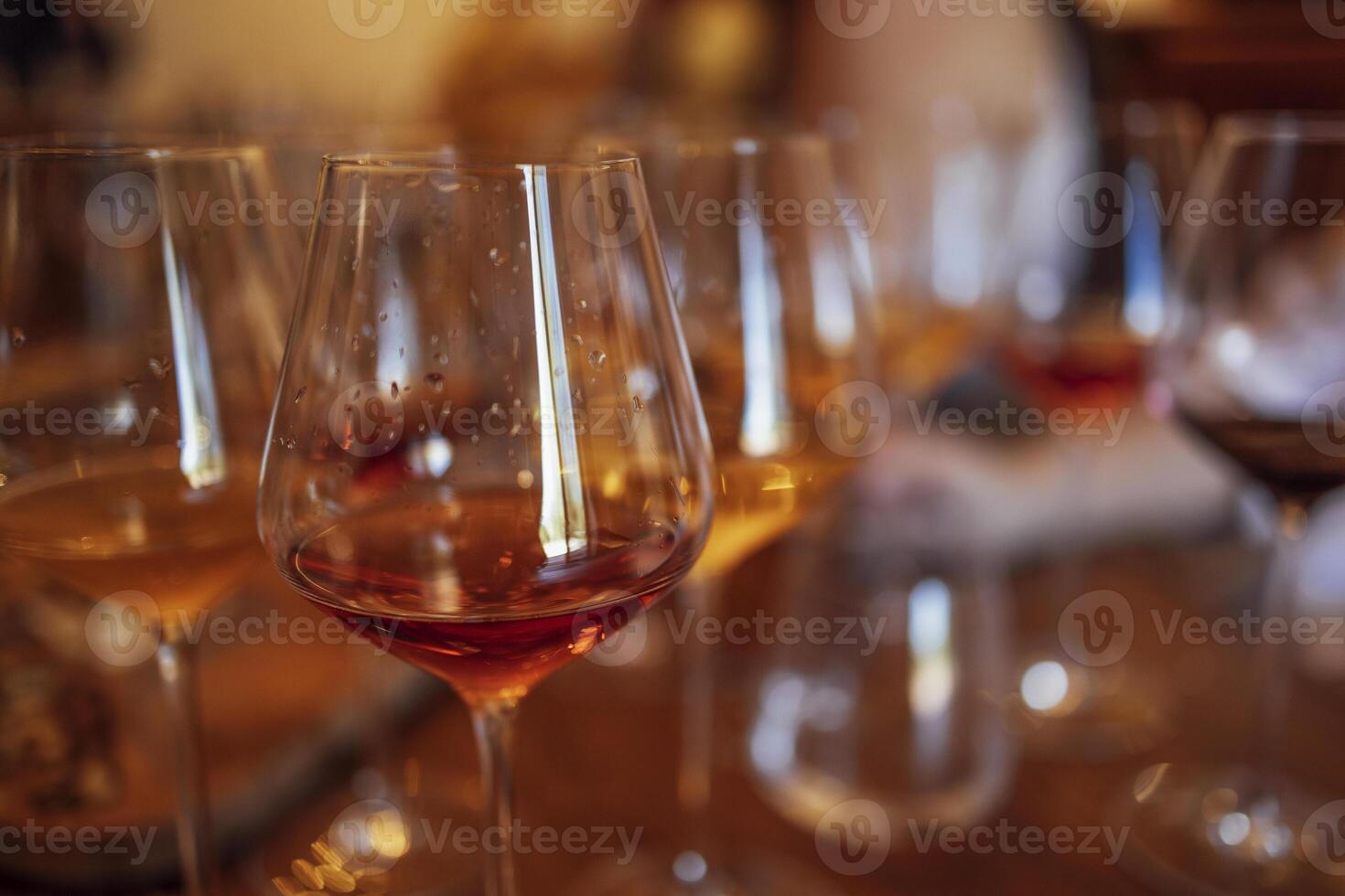 Glass goblets placed in rows on table during wine tasting procedure in restaurant photo