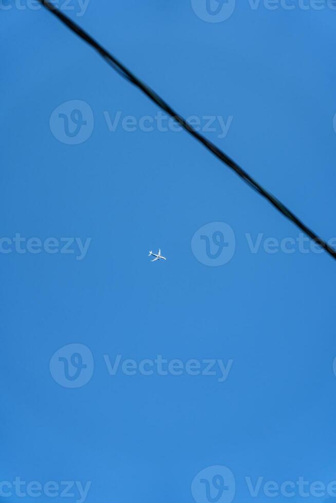 A passenger plane is flying far in the sky. Minimalism photo