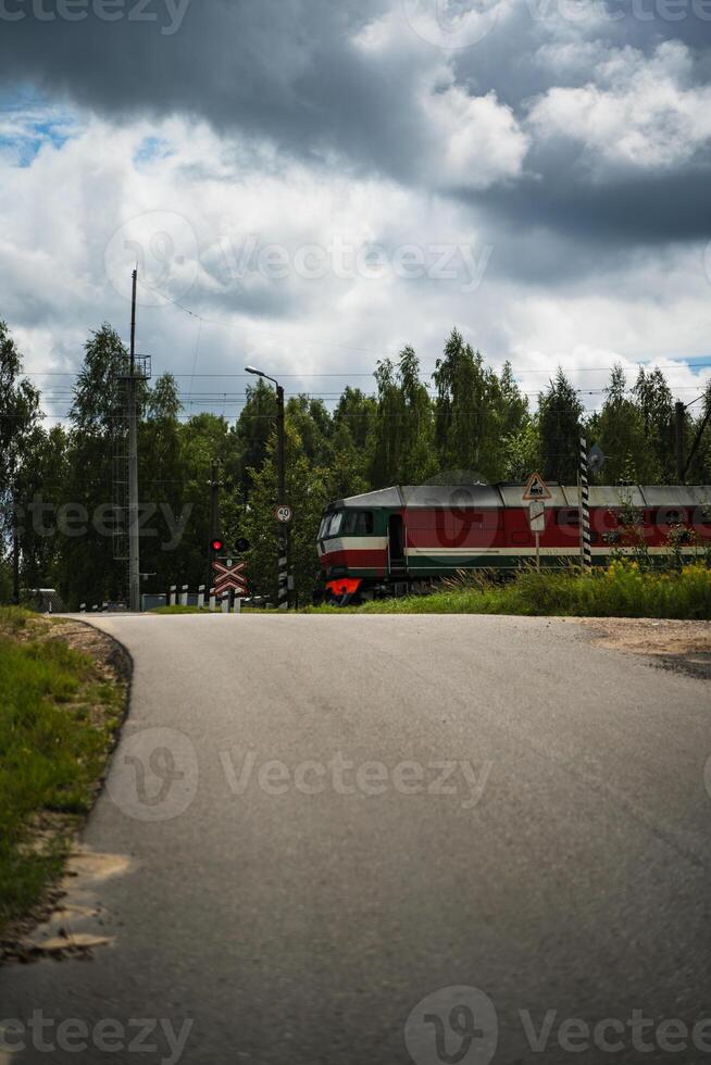 The train is standing in front of a railway crossing. Cloudy sky photo