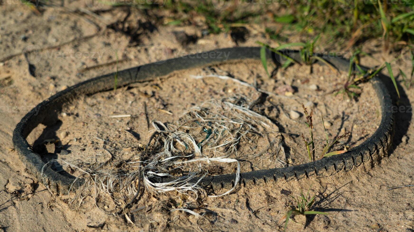 Rubber, automobile belt of the generator lies on the road sprinkled with sand photo