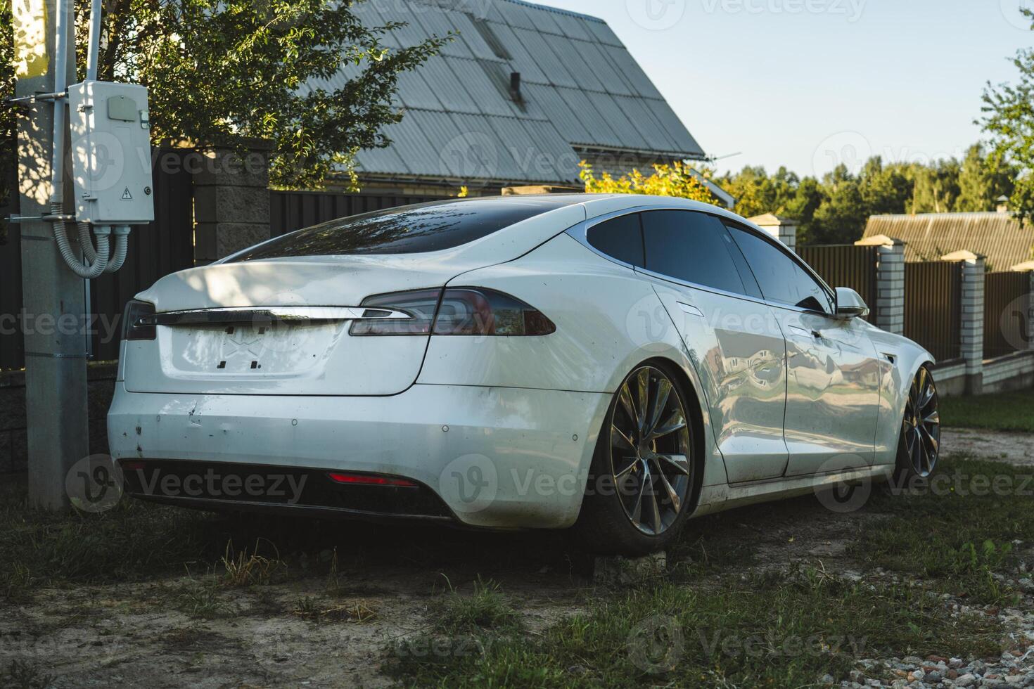 A broken Tesla model s, standing on bricks, somewhere in the village photo
