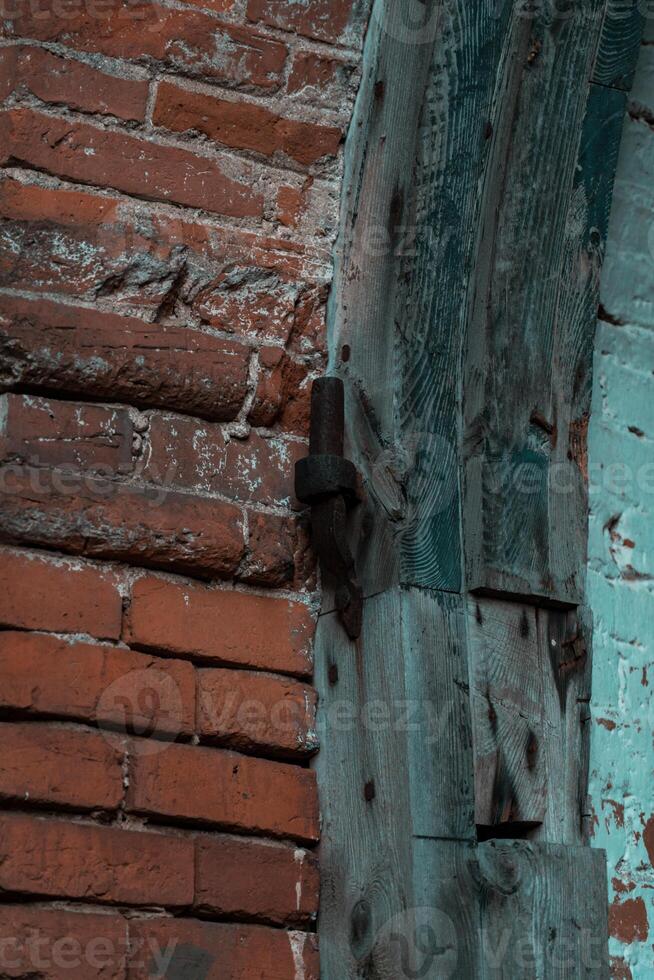 Old door hinges in the brick wall of the former stable photo