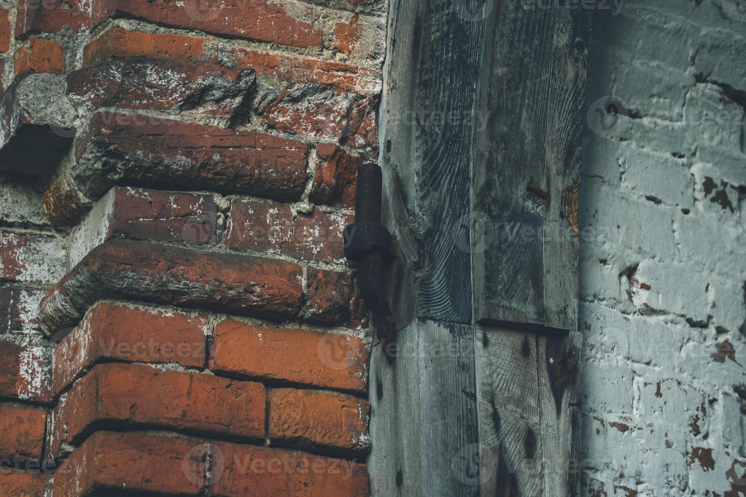 Old door hinges in the red brick wall of the former stable photo