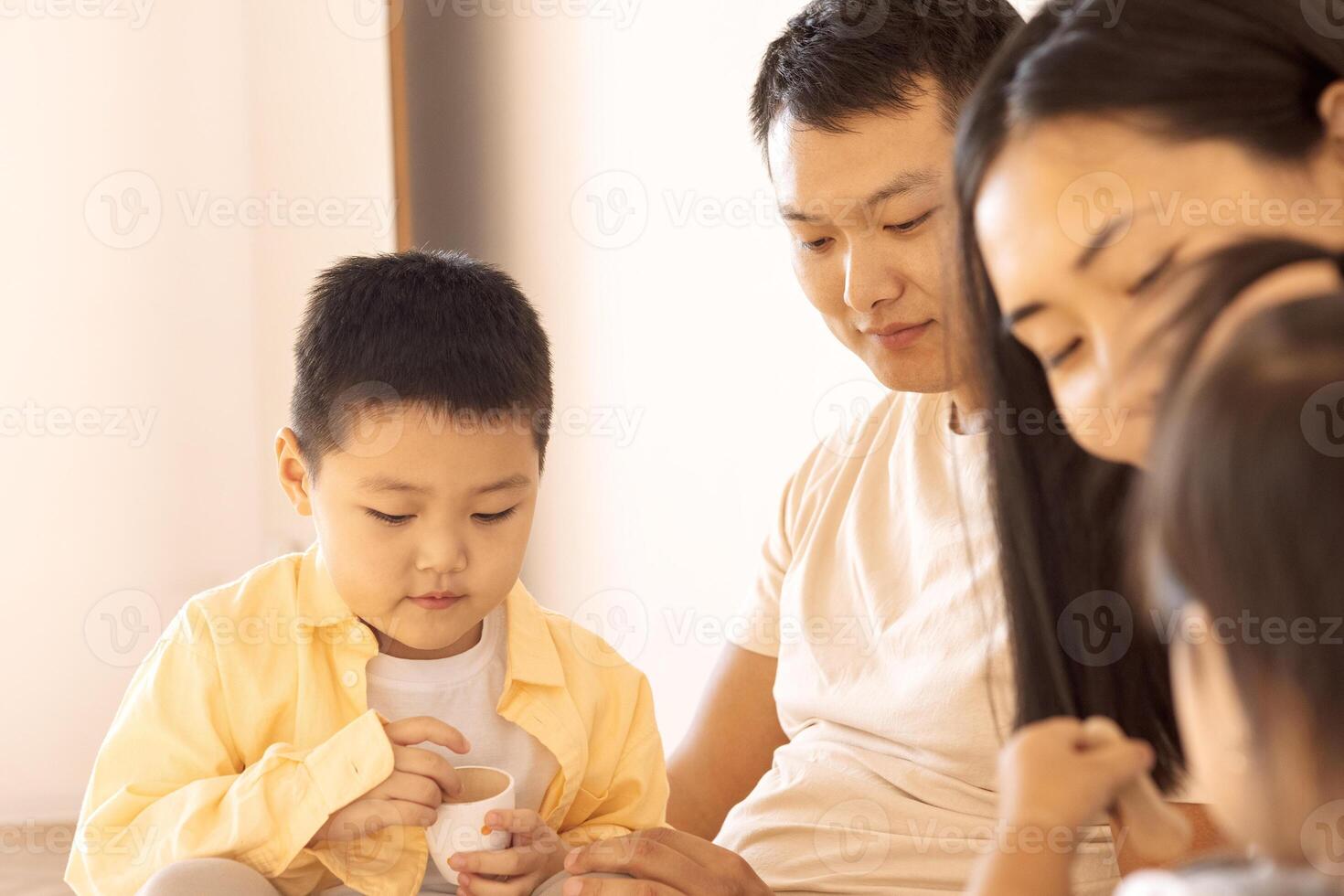 A happy Asian family. Korean parents and their cute little children play with toys at home photo