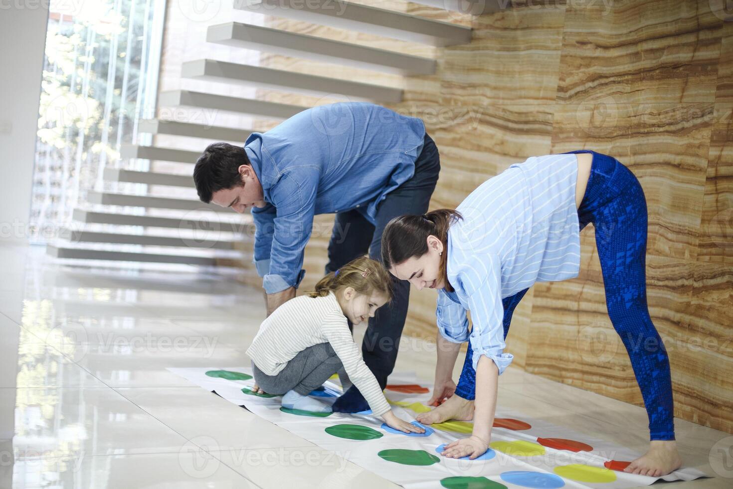 kids with father and mother playing twister game at home. Family activity photo