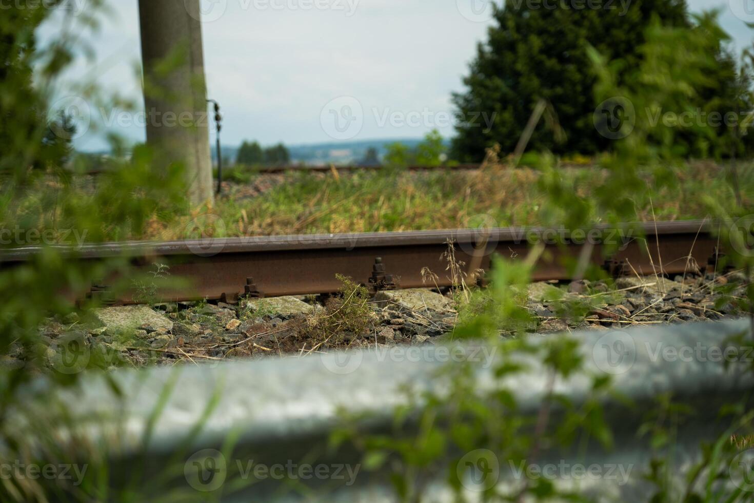 A road fence, a railway and a field in the distance photo