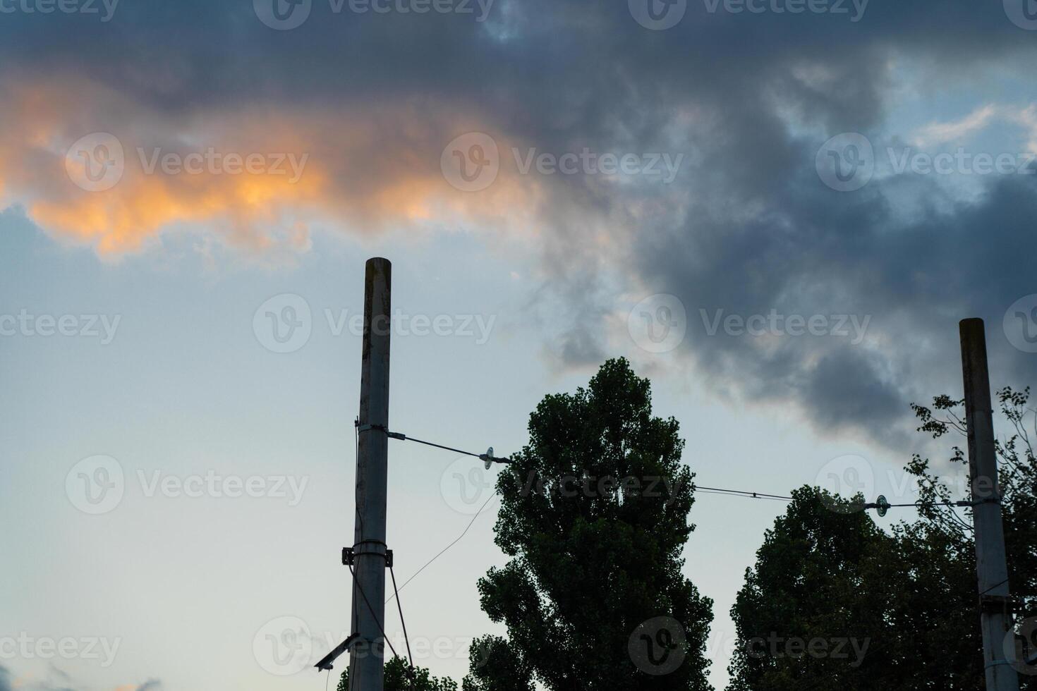 Poles of power lines against the background of sunset clouds photo