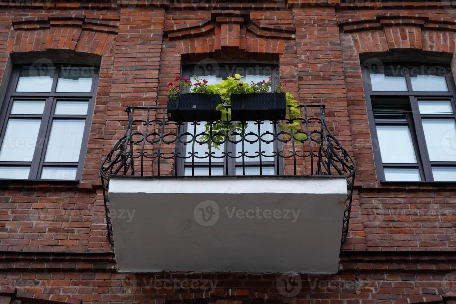 A balcony facing the street from an old brick house photo