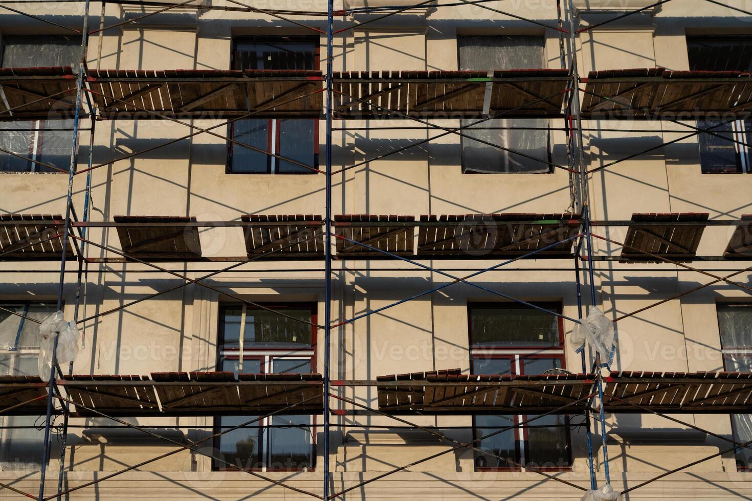 Scaffolding stands against the wall of the building. Restoration of the building photo