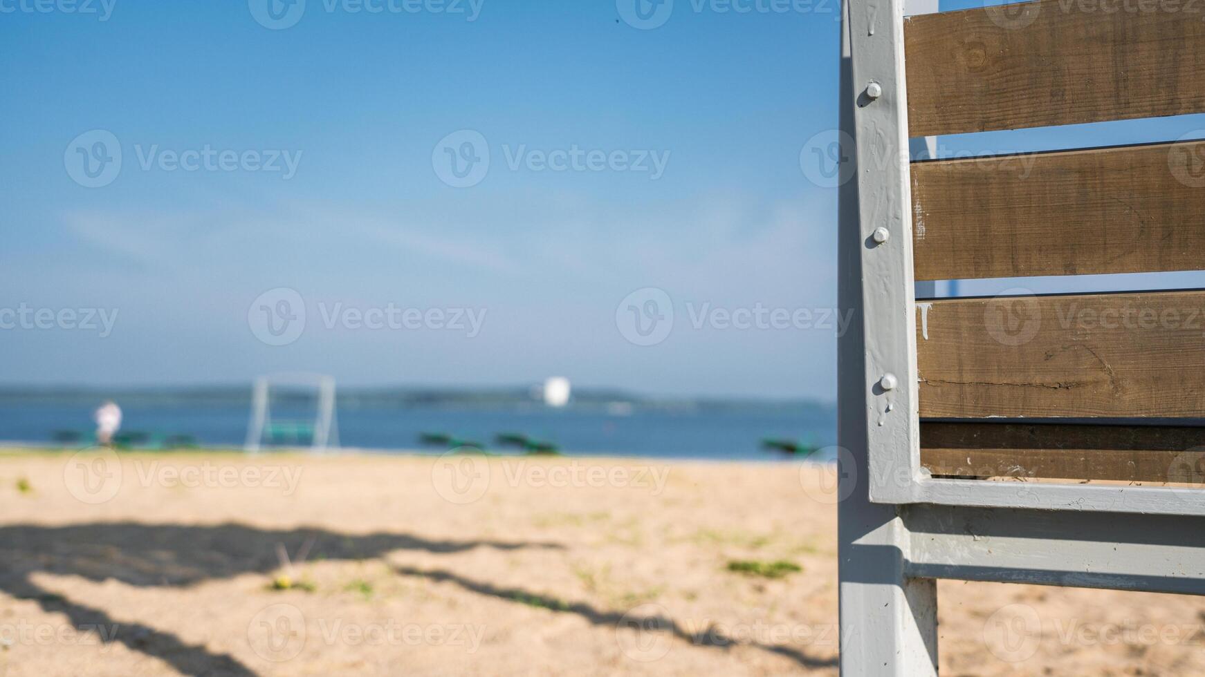 Bench on the background of the beach and lake in the early morning photo