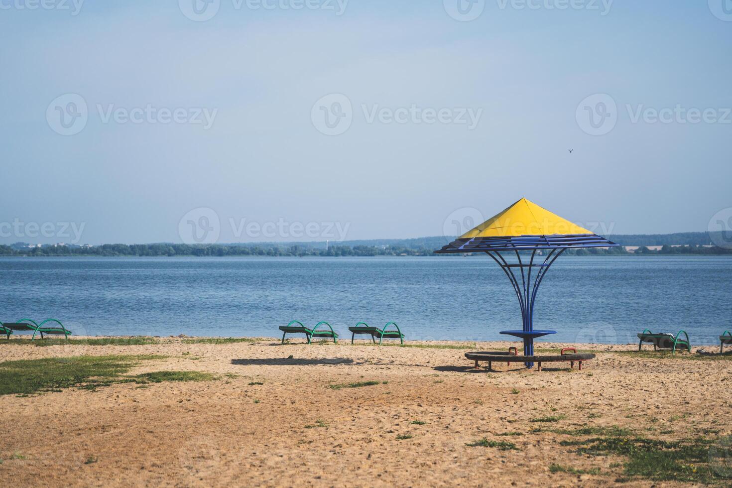Gazebos with a yellow dome on the beach by the lake photo