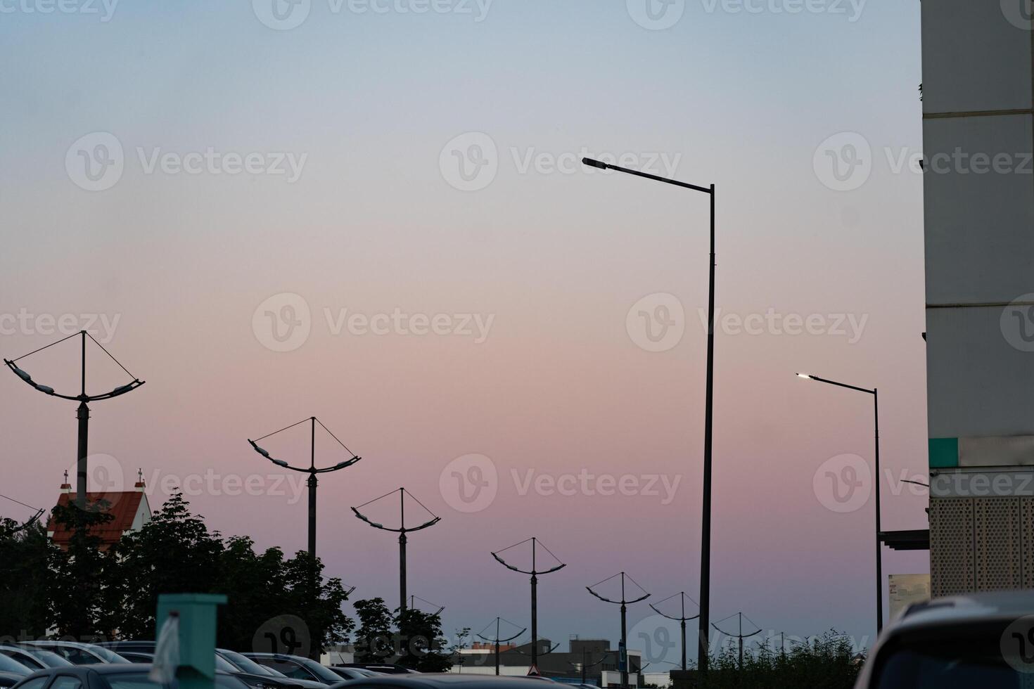 A row of street lights in the city, in the evening against the background of the sunset sky photo