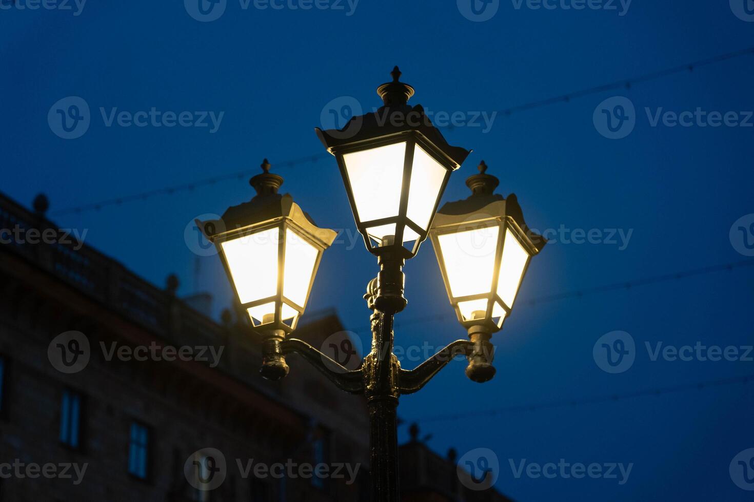 Vintage street lamp on the background of the building, in the evening in the city photo