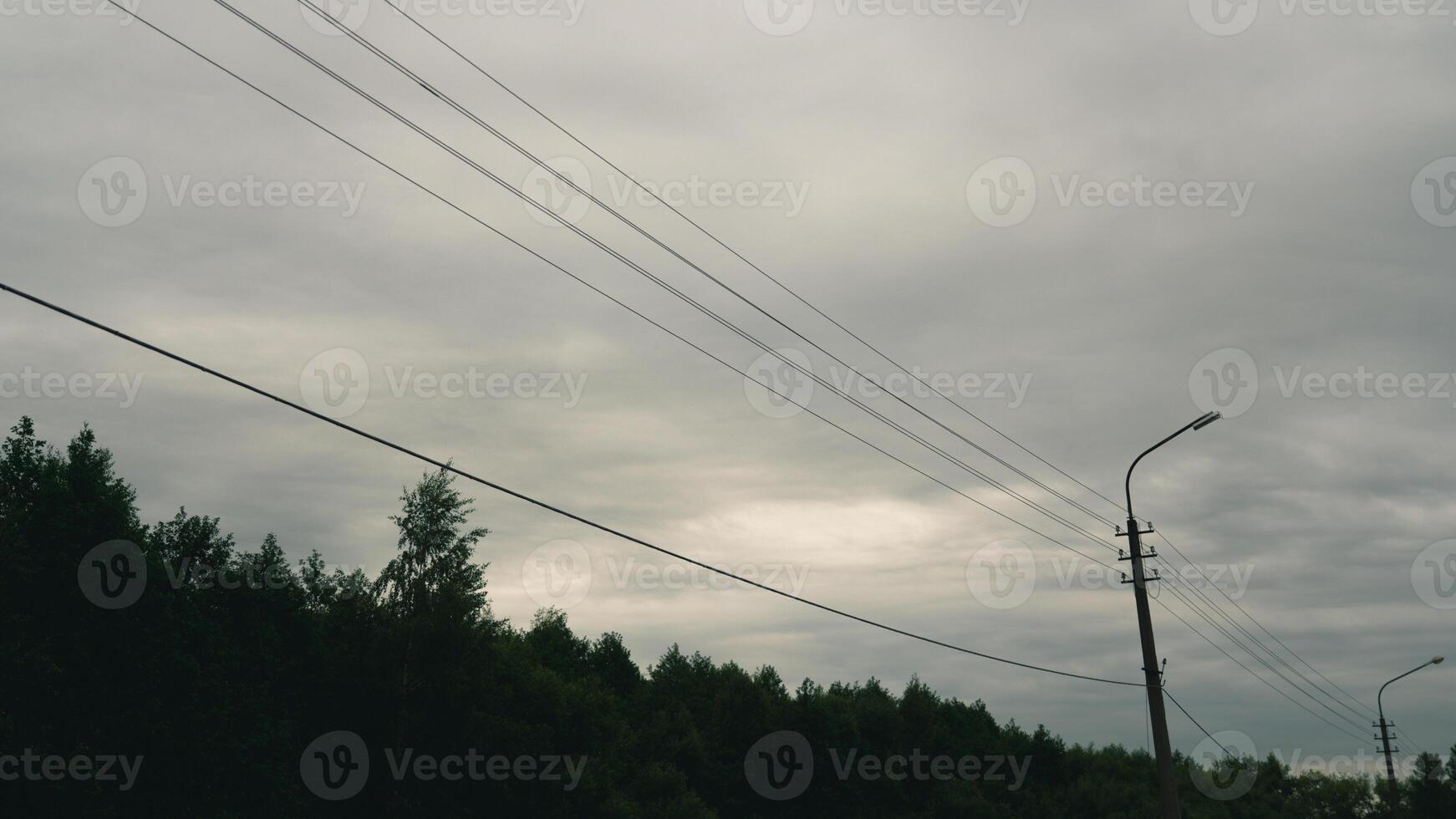 The wires of a street lamp against a cloudy sky photo