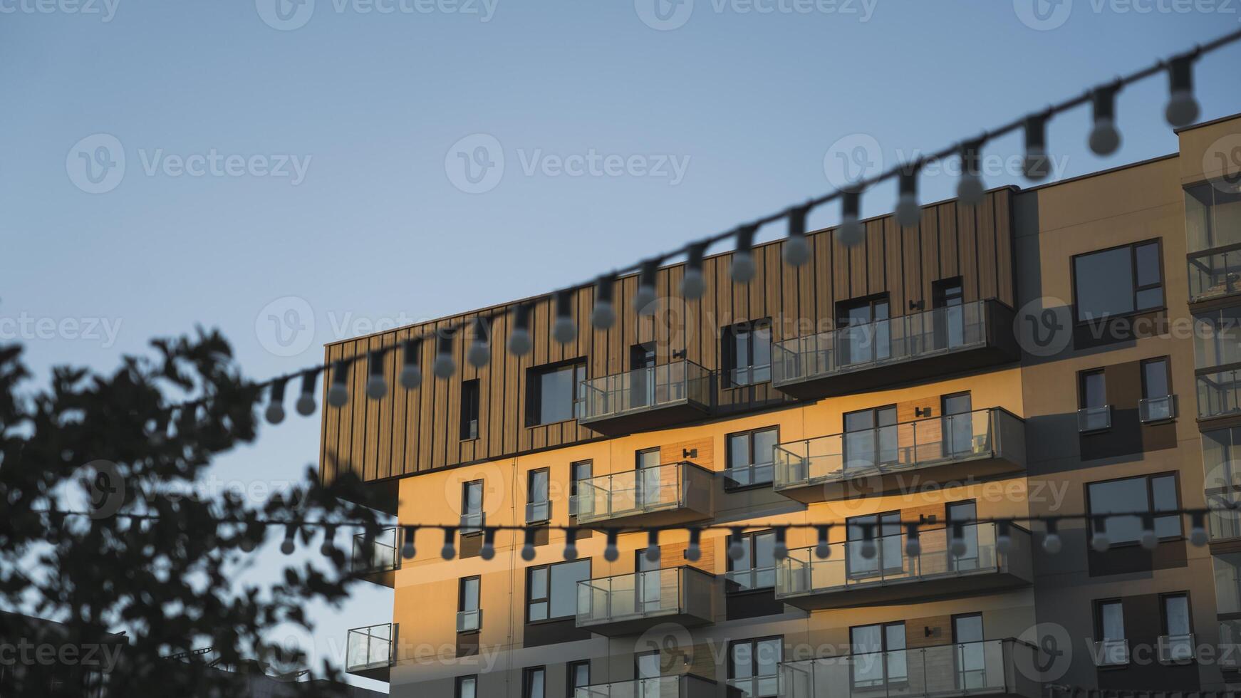 Modern residential building, against the background of the evening sky, and street lights photo