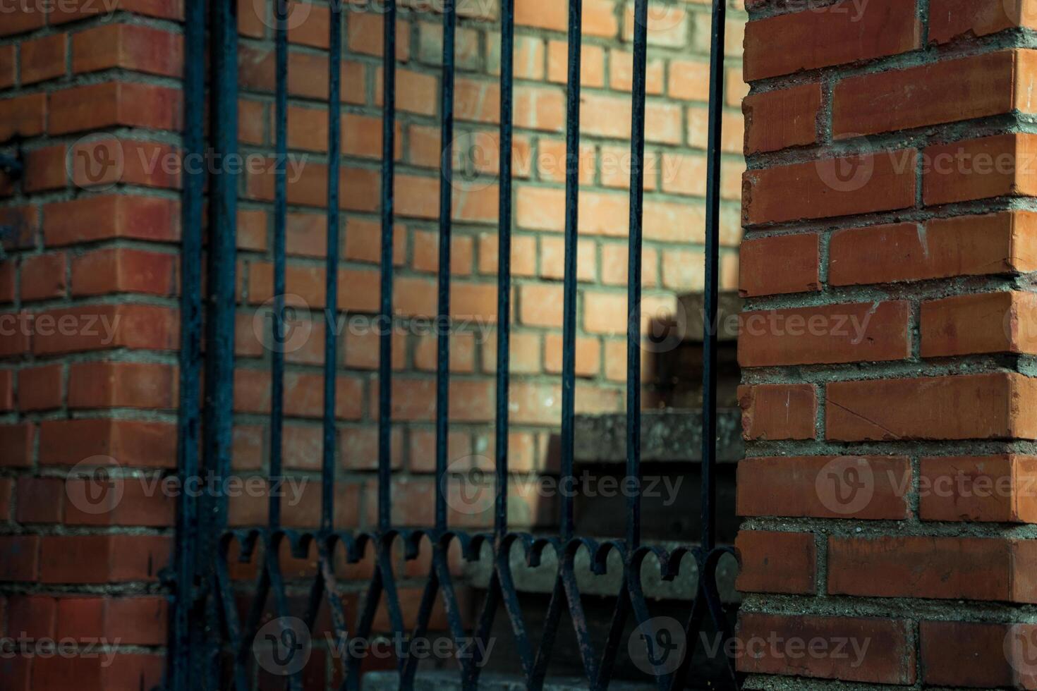 concrete steps behind a metal, wrought-iron gate in a brick building photo