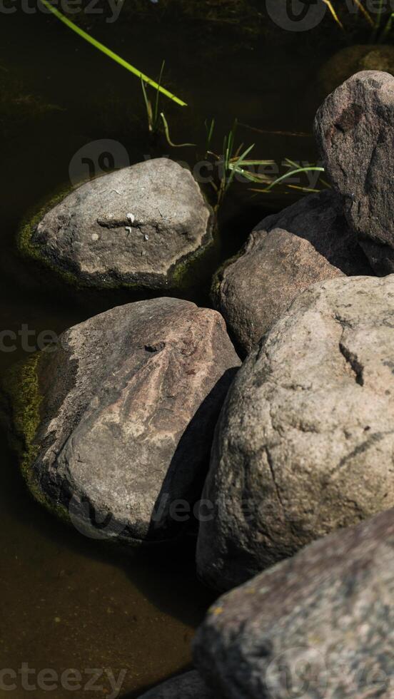 Large rocks, boulders near the shore of a large water utility photo