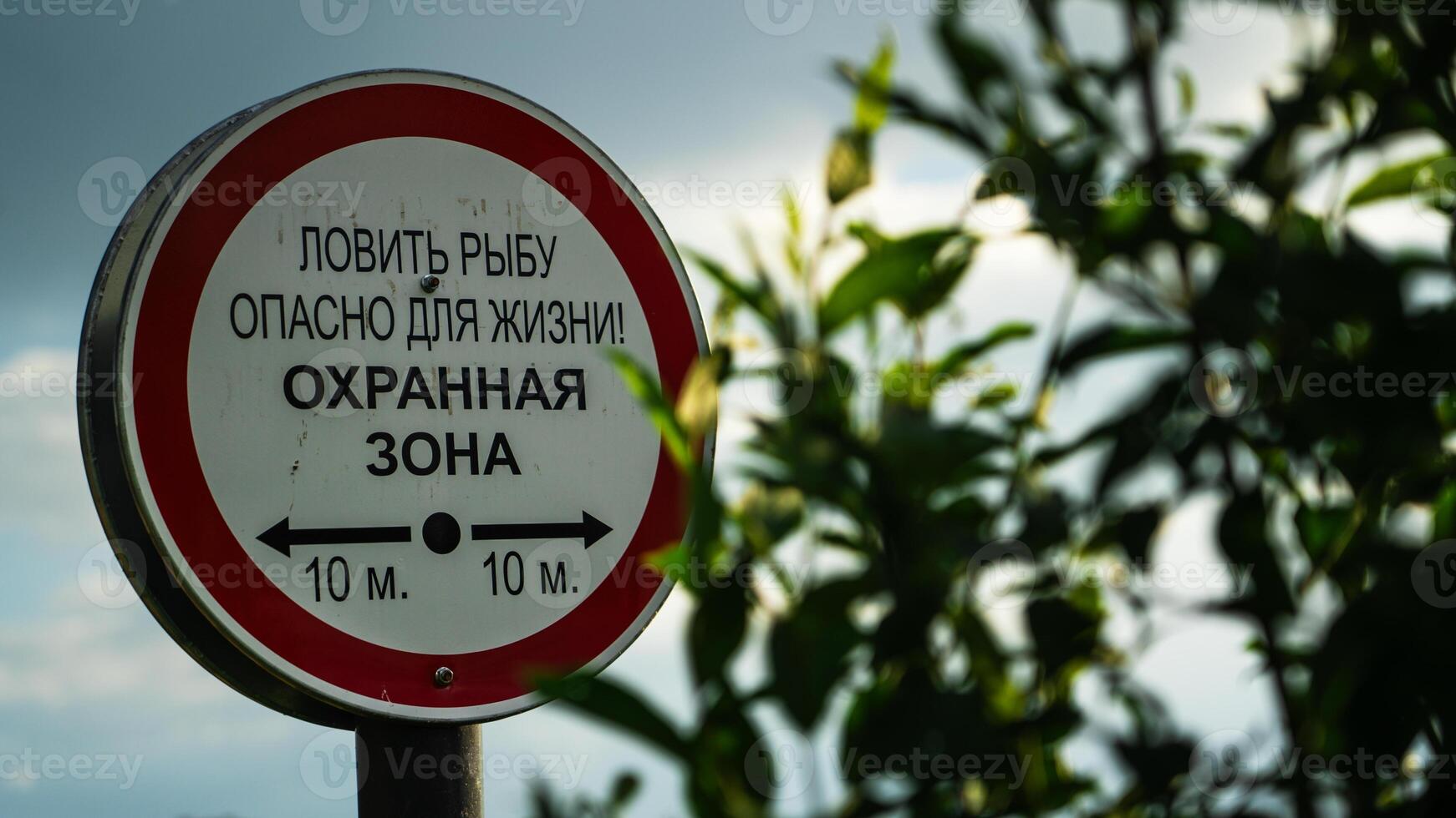 A warning sign by the river Fishing is life-threatening. Security zone photo