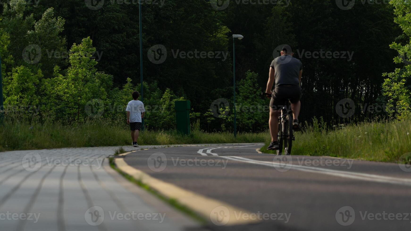 A cyclist and a runner move along a bike path photo