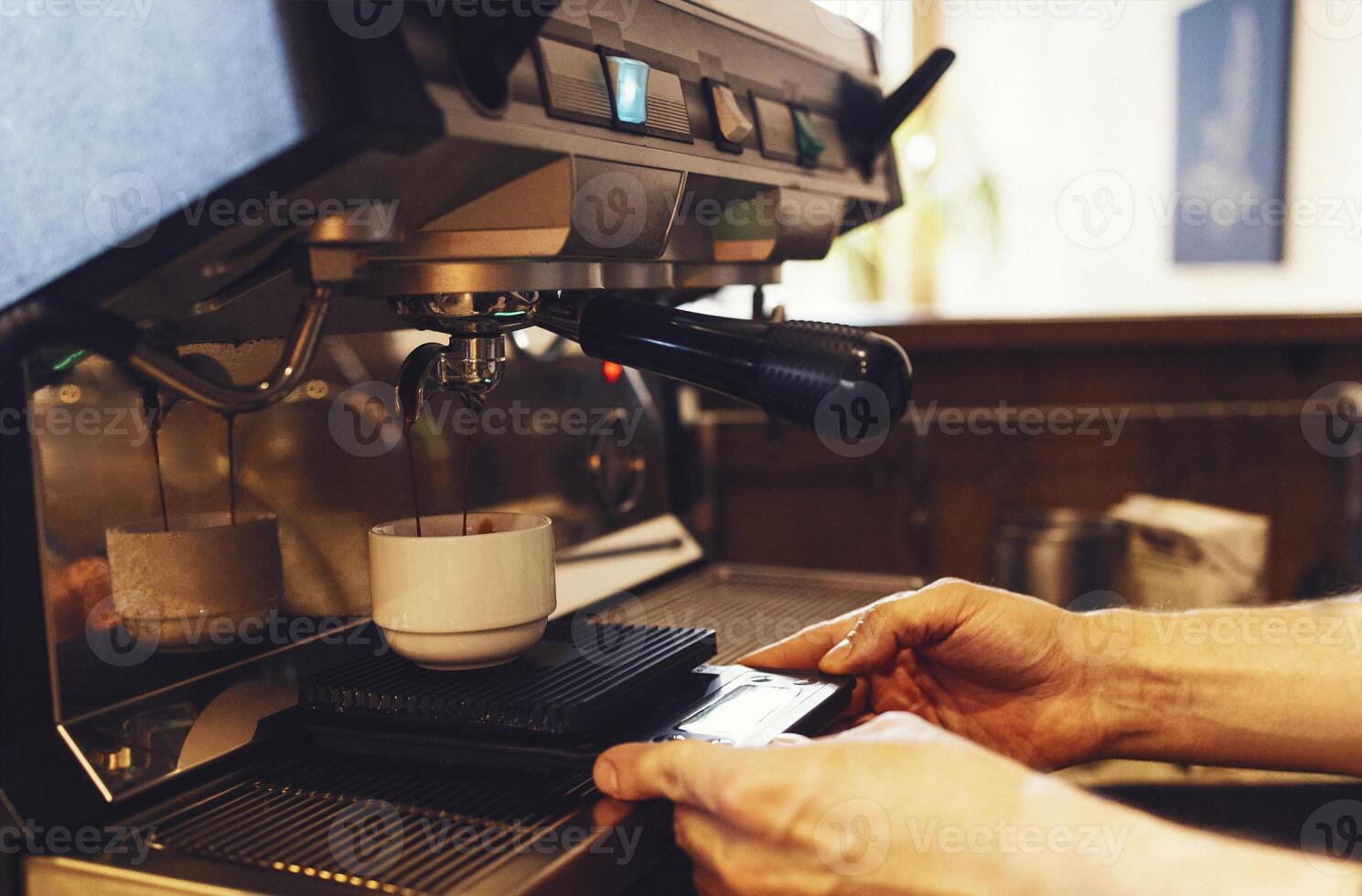 Close up of espresso pouring from coffee machine photo