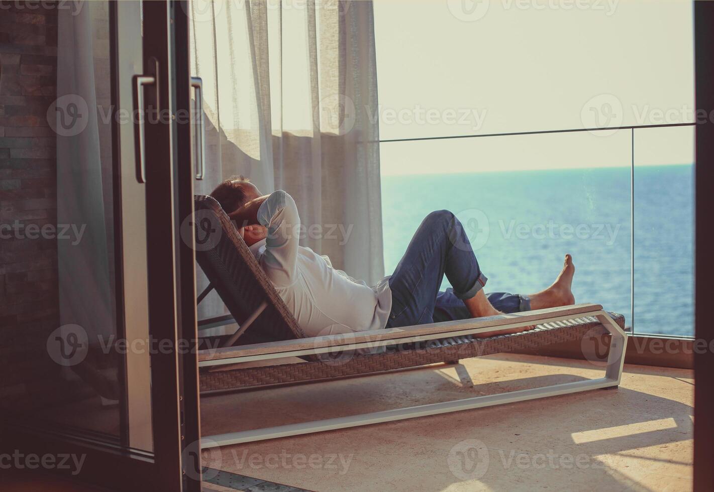 Relaxed young man at home on the balcony photo