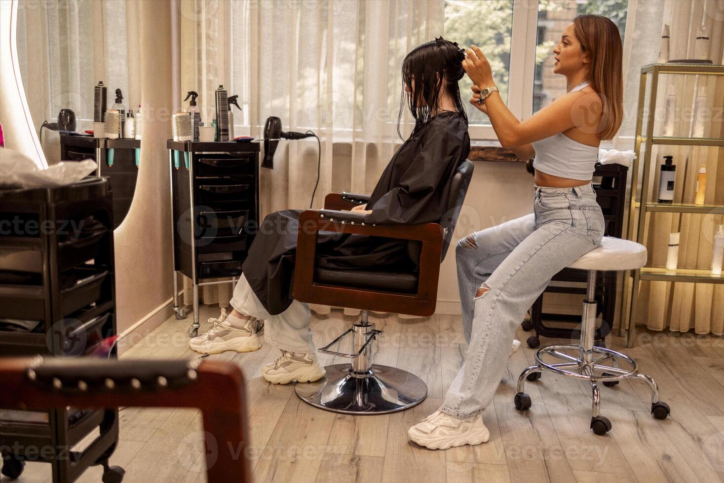 hairdresser cuts hair of woman while working in beauty salon photo