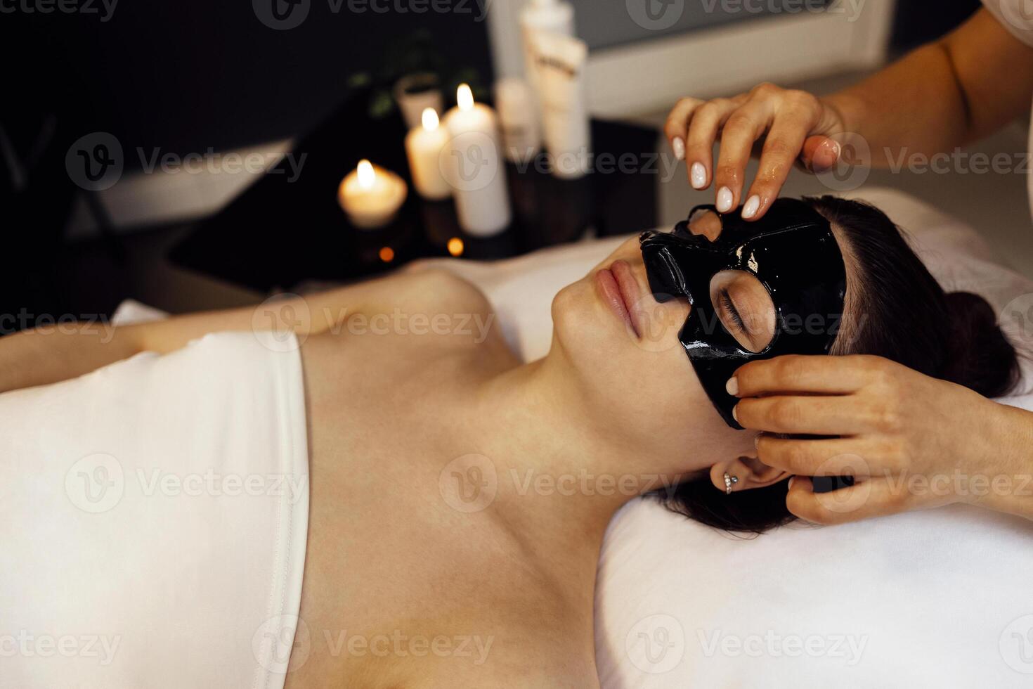 Pretty brunette female with cosmetic mask on her face. Skin care c photo