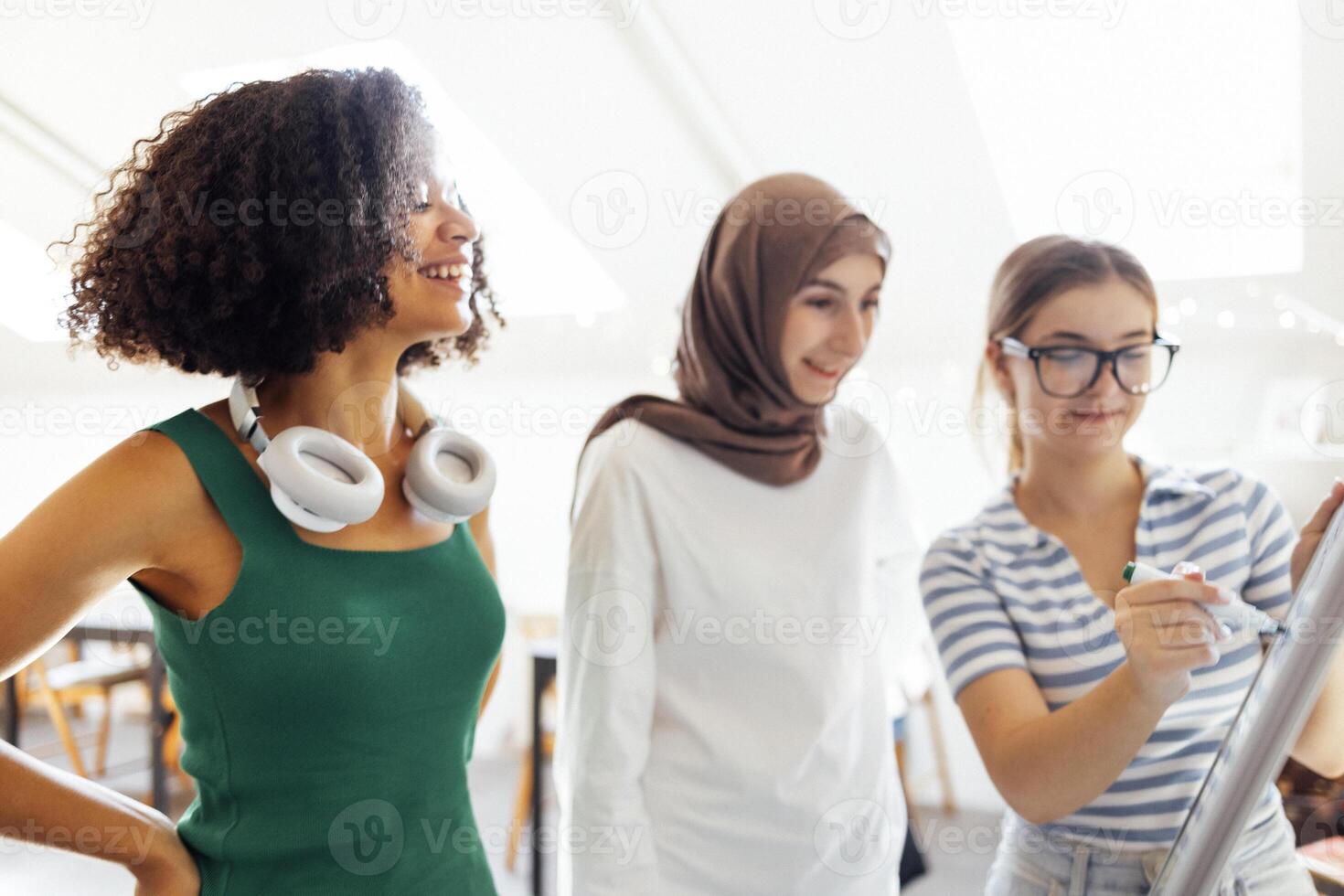 Brainstorming of three teenagers. Teens of different nationalities and religions solve problems together. photo