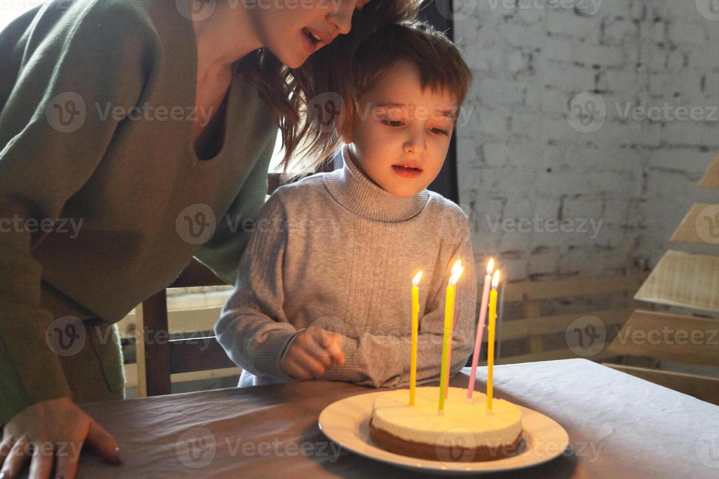 Little preschool caucasian boy blowing out candles on homemade birthday cake at home, kid making wish during birthday celebration with family photo