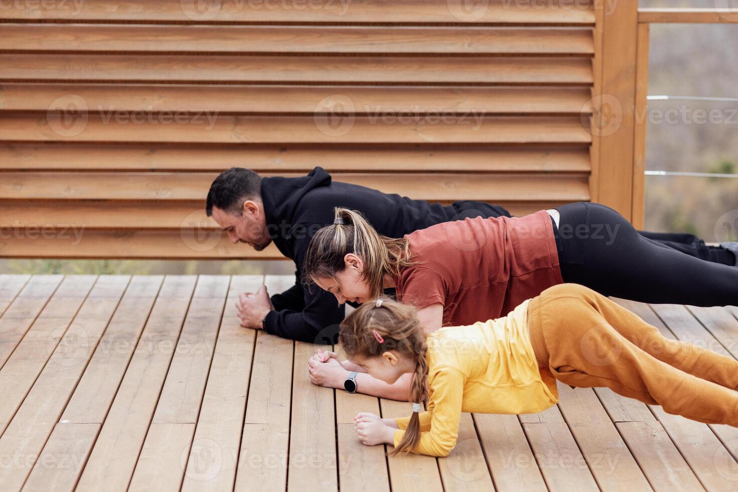 a man and woman doing push ups with a child photo