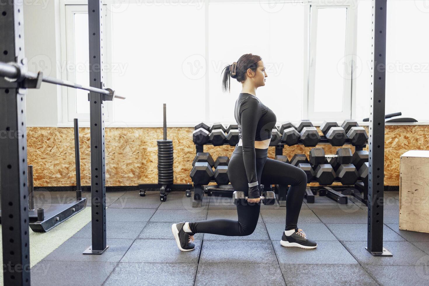 Strong brunette female doing crossfit workout photo