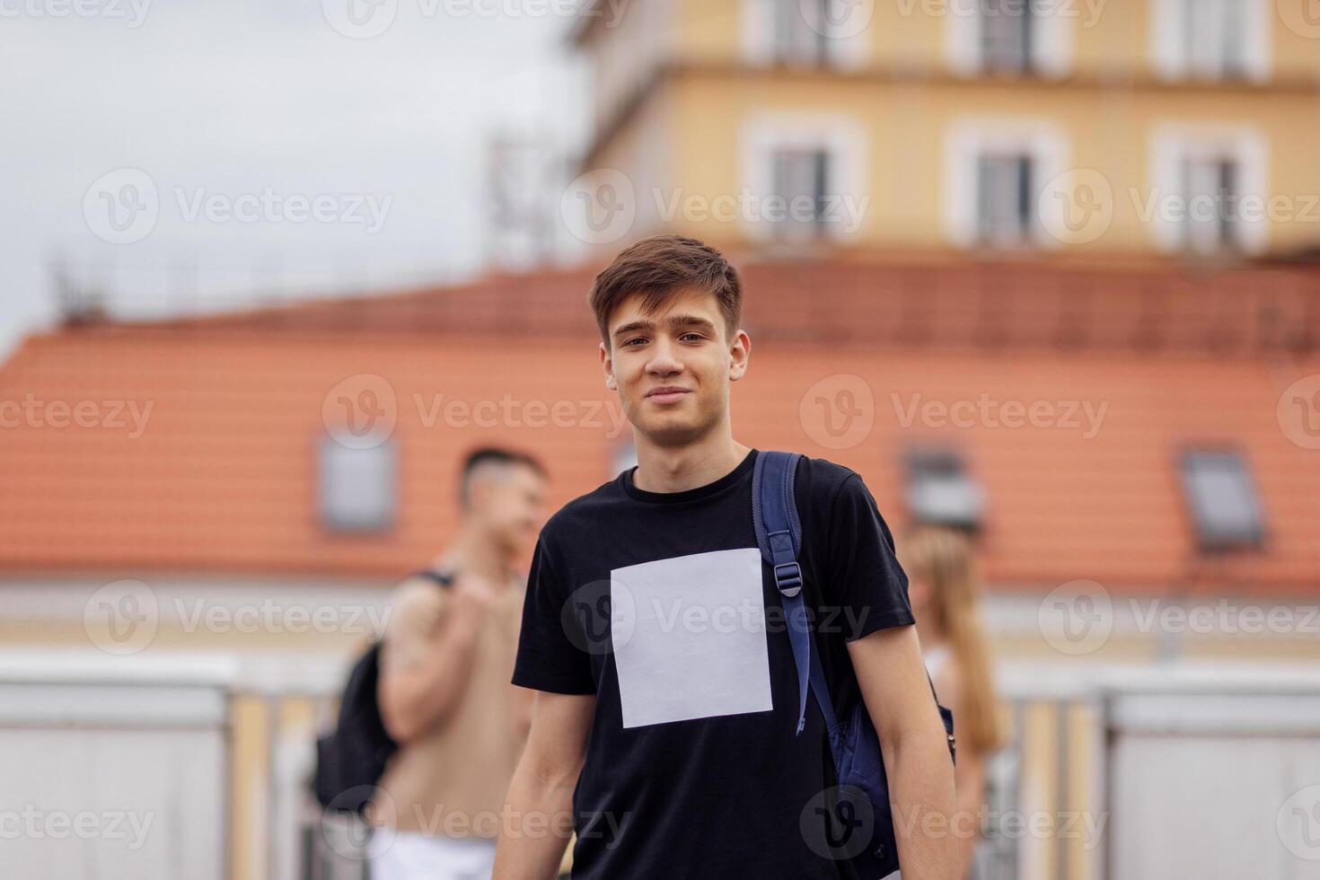 Close-up of a male portrait of a cute guy in a beige T-shirt with a black backpack photo