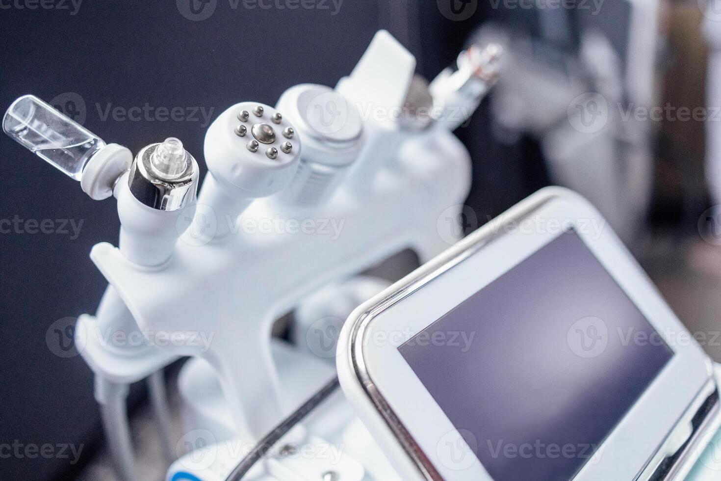 Extreme close up of empty glass bottle for serum on ultrasonic hydromassage beauty apparatus photo