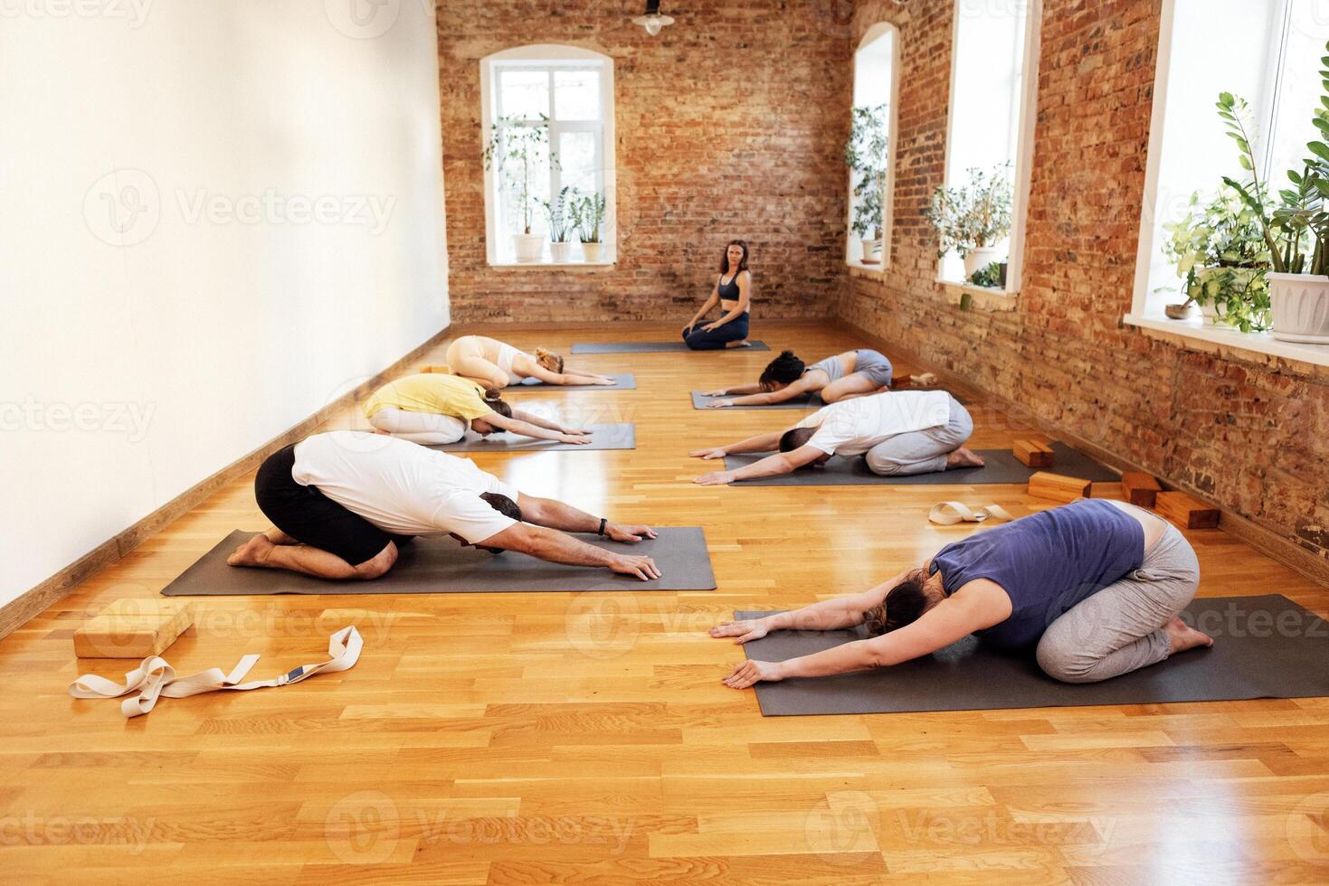 A group of young athletic people are lying on mats after practicing a yoga or Pilates lesson photo