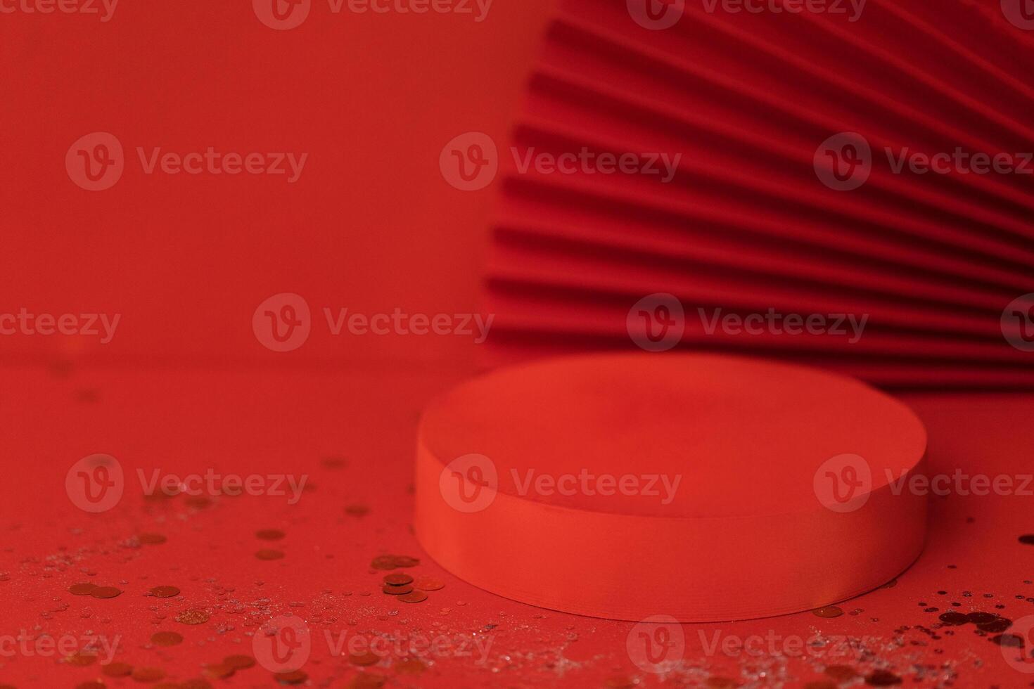 Empty holiday template for design with red round stage. Bright background with sparkles and confetti. Red paper fan on backdrope. photo