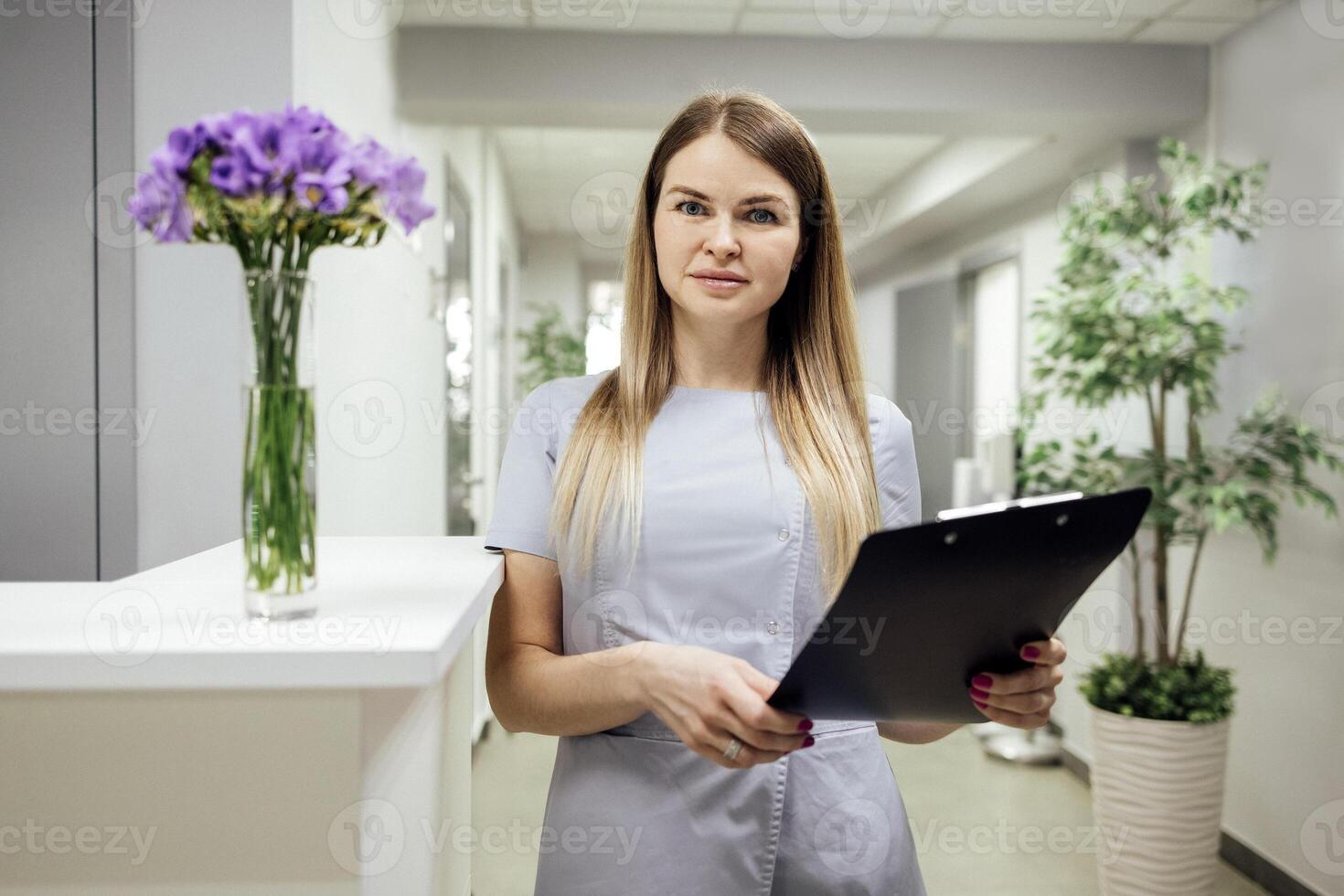 Beautiful female blonde with with paper forms at the reception. photo