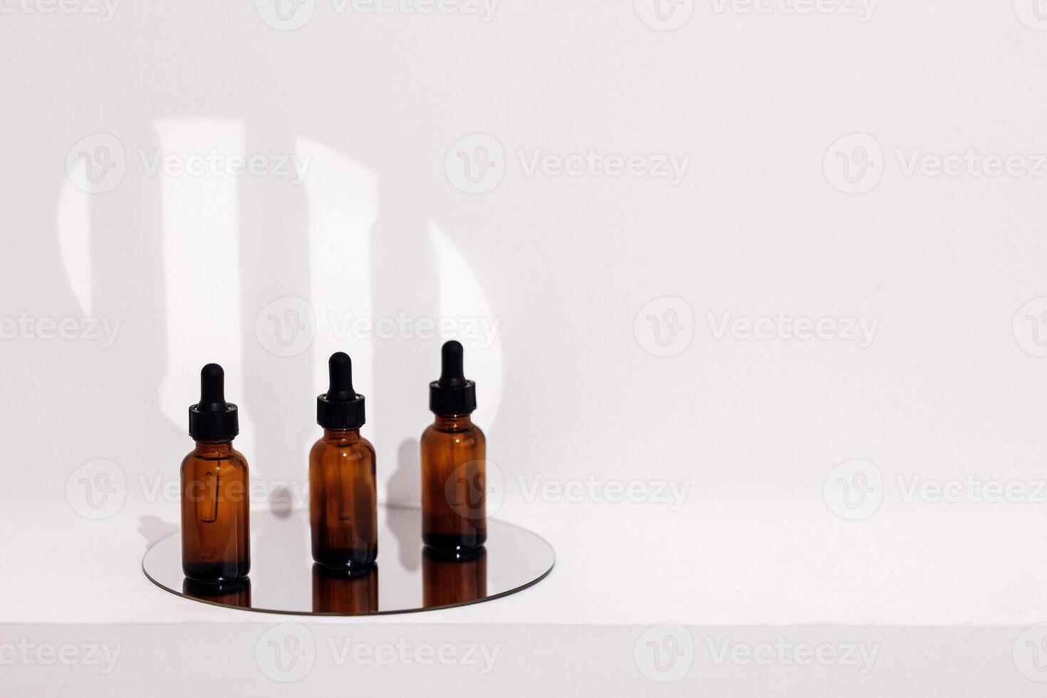 Group of brown bottles and their reflection on a mirror surface photo