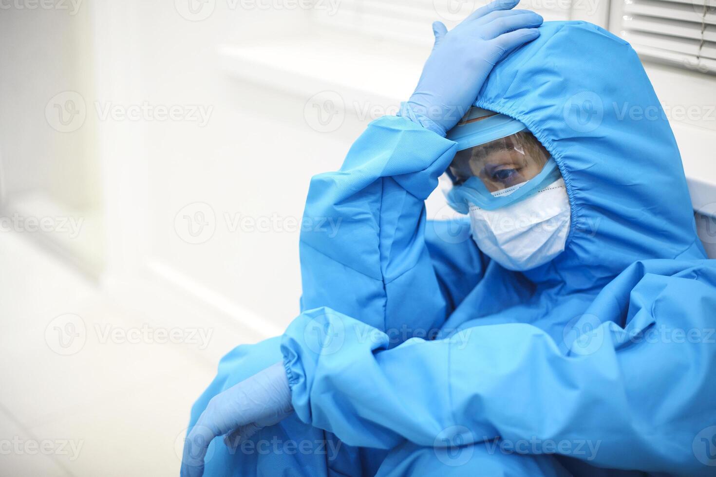 Tired depressed nurse in personal protective equipment PPE after difficult shift during Covid-19 photo