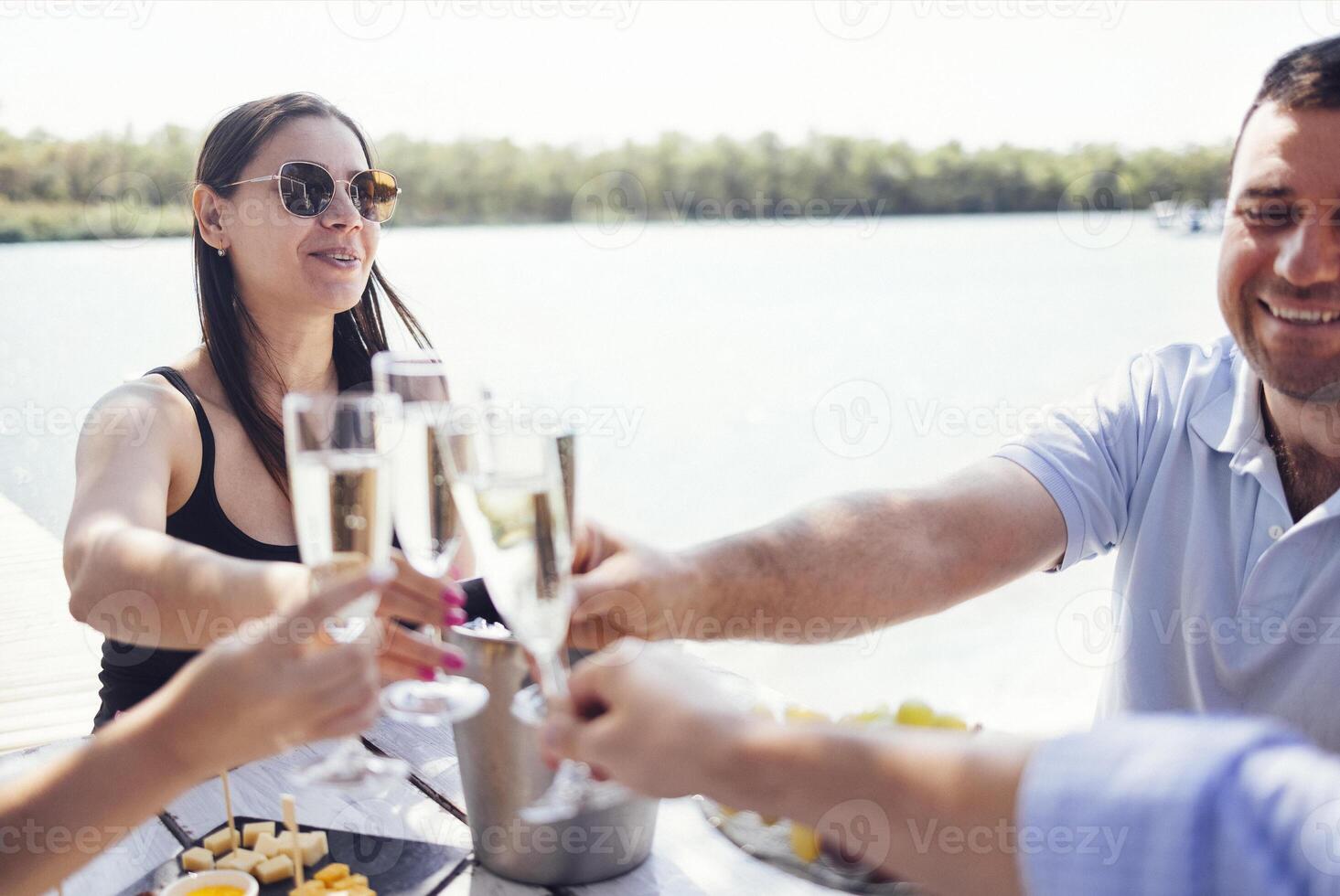 Happy people on the beach having a party, drinking and having a lot of fun in the sunse photo